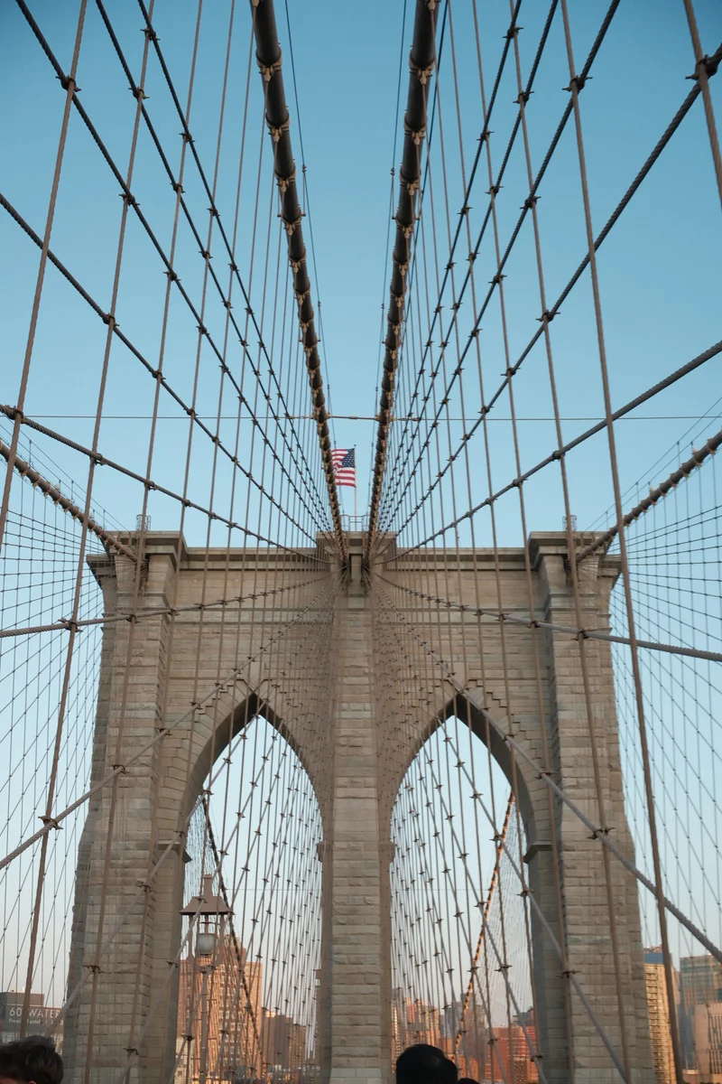 The Brooklyn Bridge's stone arches rise through a web of suspension cables.